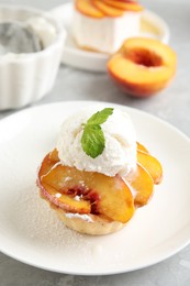 Photo of Delicious peach dessert with ice cream on table
