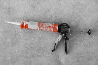 Photo of Gun with tube of sealant on floor, top view