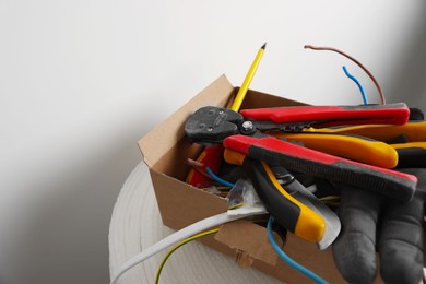Photo of Different tools and cables in paper indoors. Installation of electrical wiring