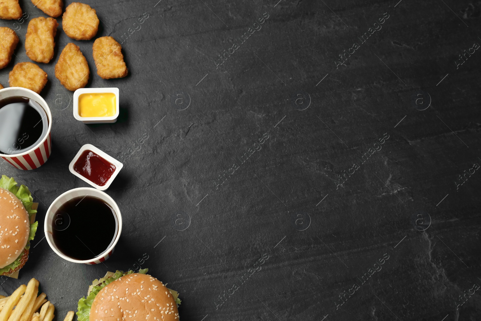 Photo of Flat lay composition with delicious fast food menu on black table. Space for text