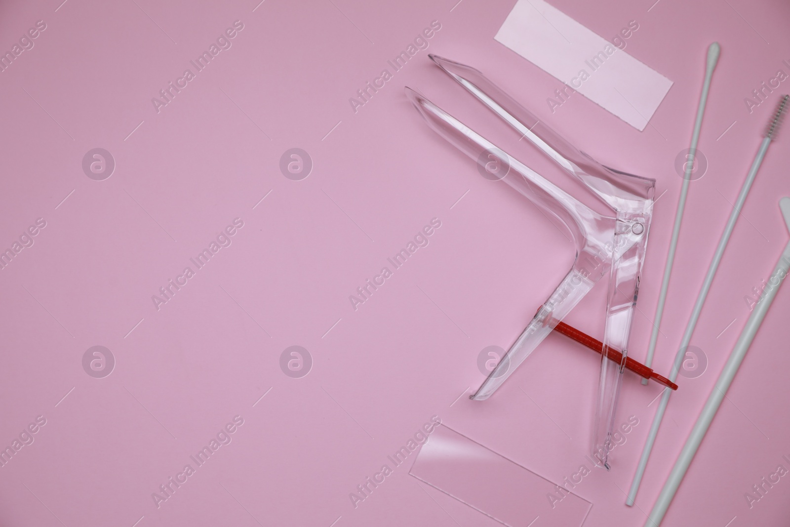 Photo of Sterile gynecological examination kit on pink background, flat lay. Space for text