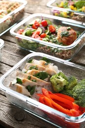 Photo of Healthy meal. Containers with different products on wooden table, closeup