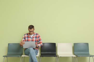 Photo of Man with laptop waiting for job interview indoors