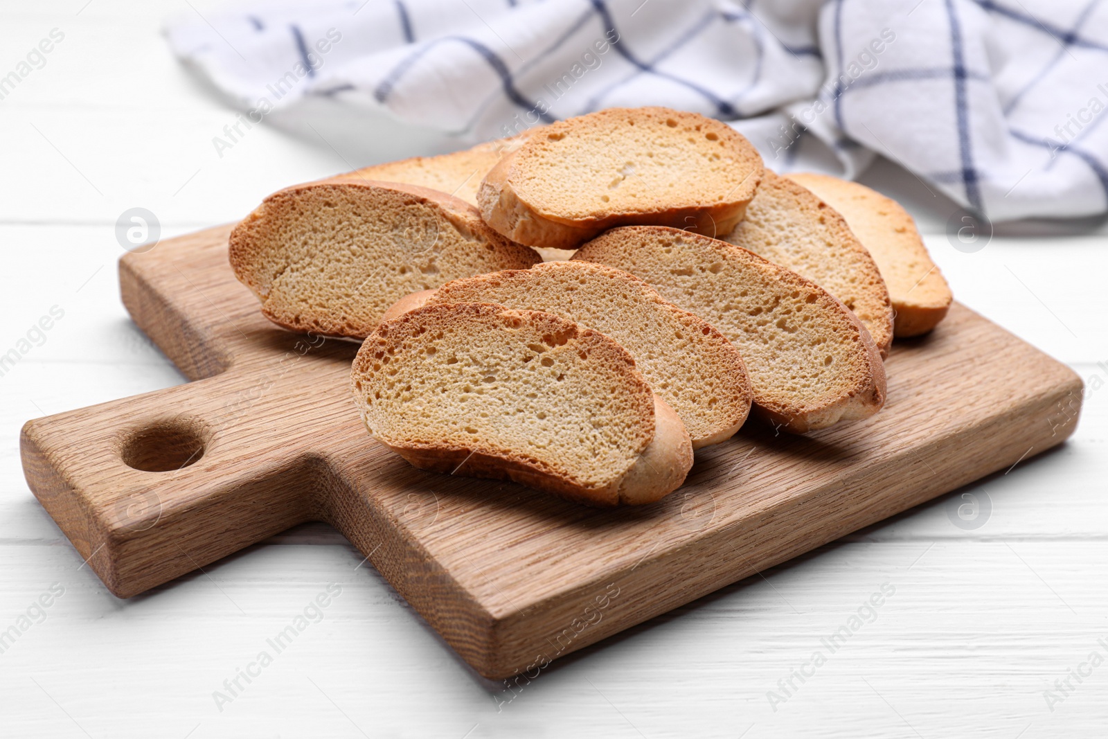 Photo of Tasty hard chuck crackers on white wooden table