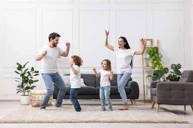 Photo of Happy family dancing and having fun in living room