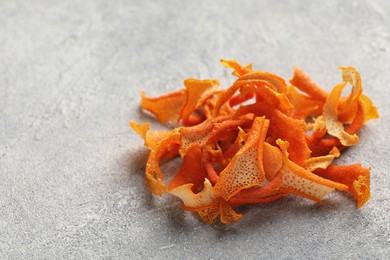Photo of Dry orange peels on light gray textured table, closeup. Space for text