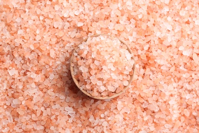 Pink himalayan salt and wooden bowl as background, top view