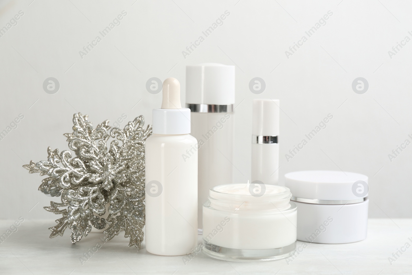 Photo of Beautiful composition with different cosmetic products on white table. Winter care