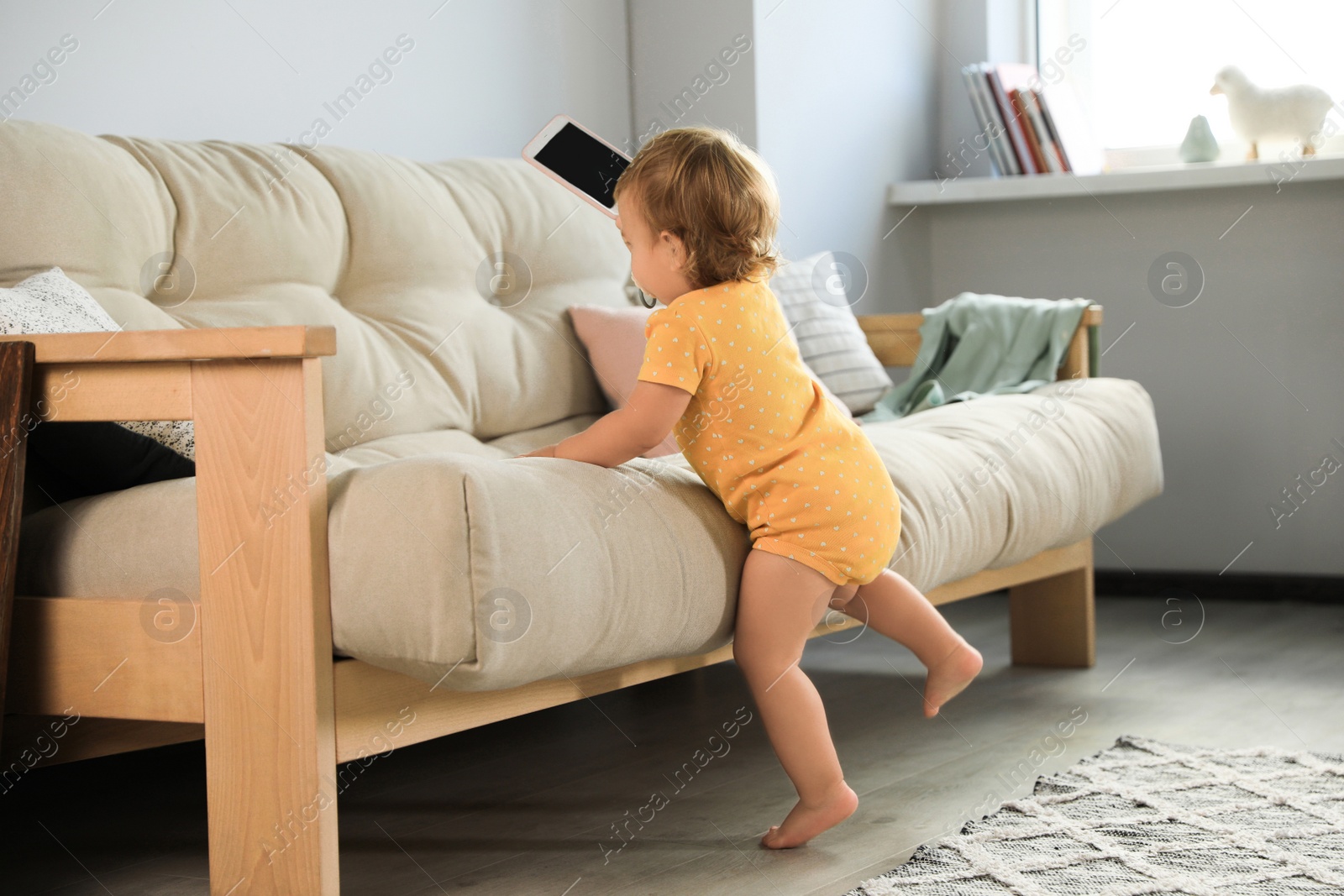 Photo of Cute baby learning to walk in living room