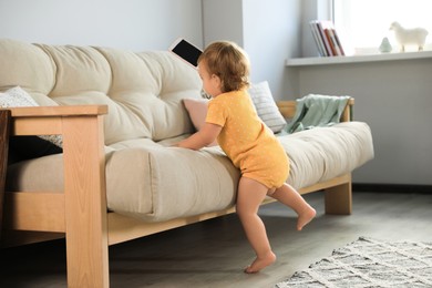 Cute baby learning to walk in living room