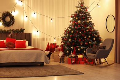 Beautiful Christmas tree and festive decorations in bedroom