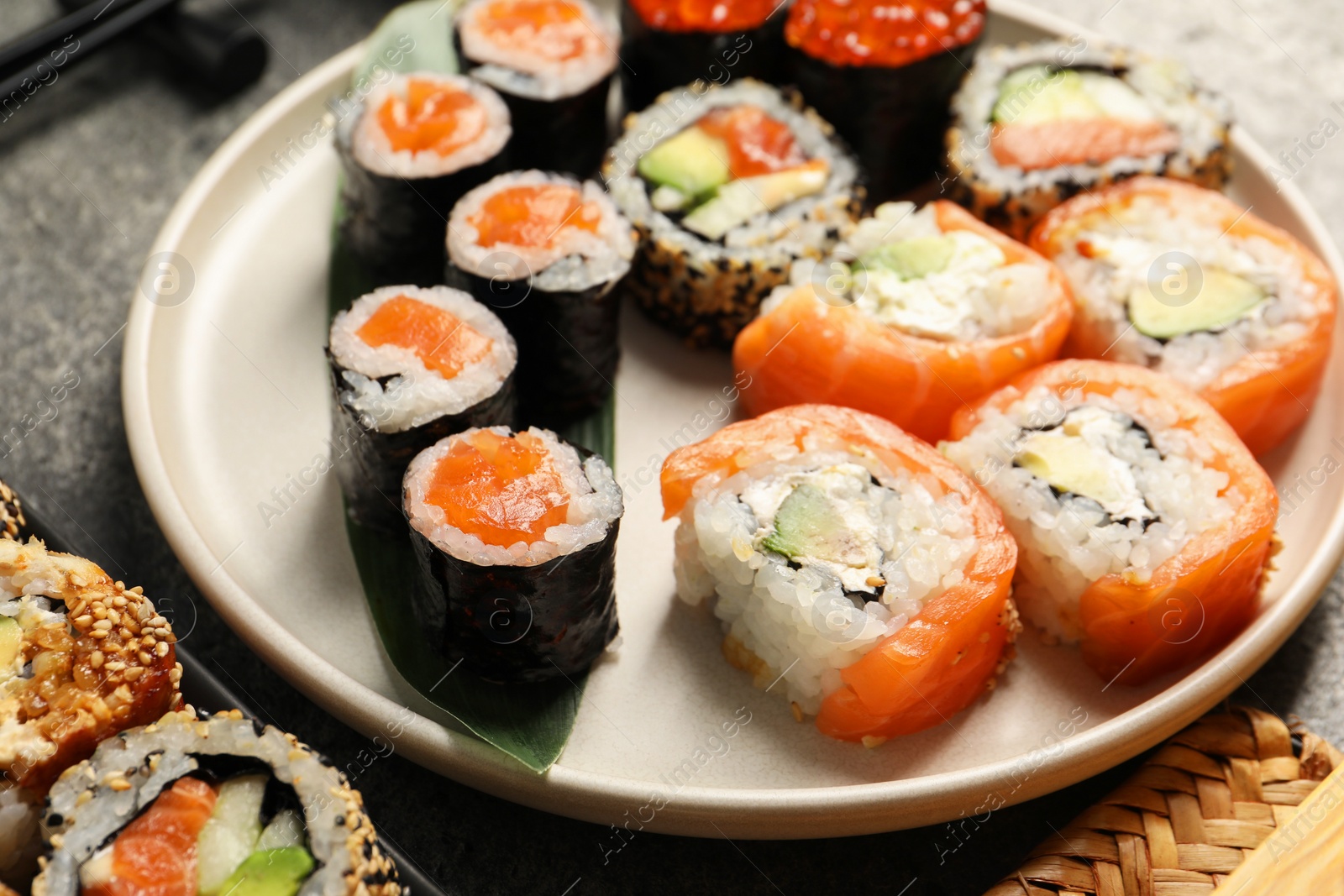 Photo of Delicious sushi rolls on grey table, closeup