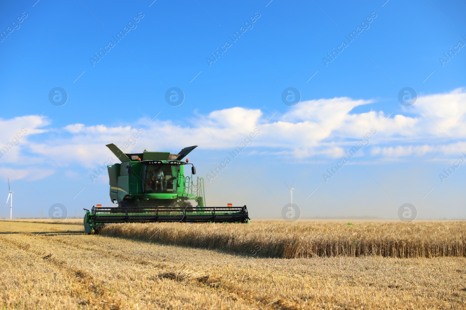 Photo of Modern combine harvester working in agricultural field