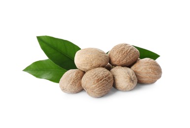 Photo of Nutmeg seeds with green leaves on white background