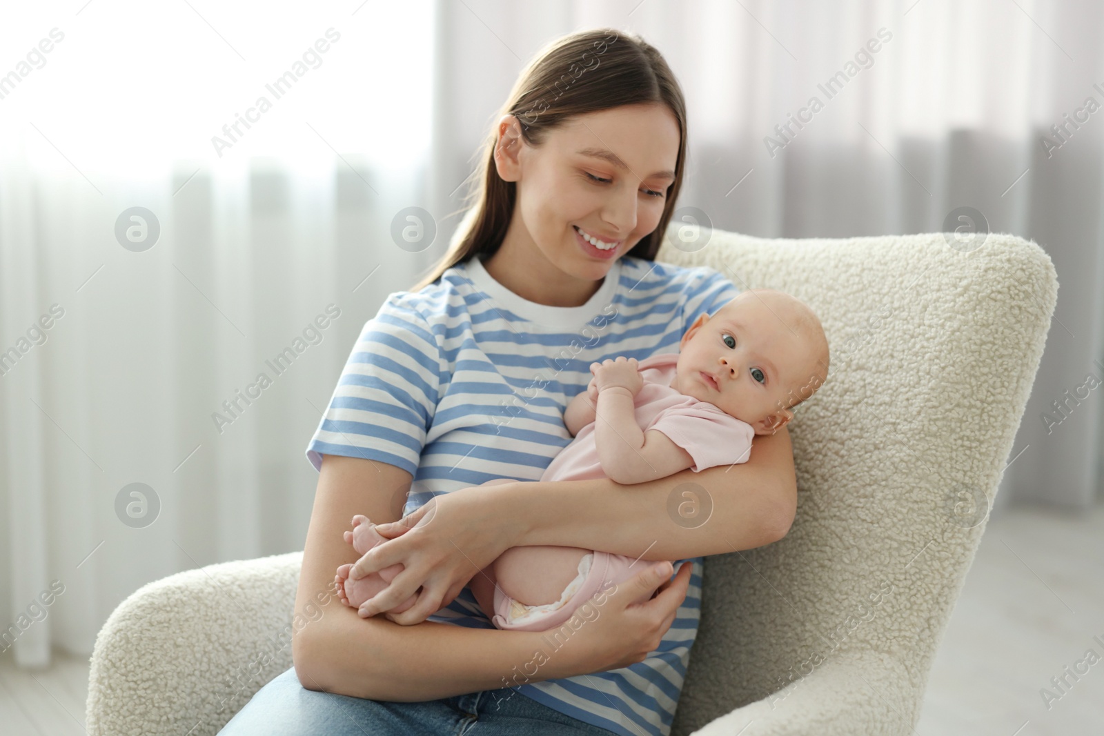Photo of Mother with her cute baby in armchair at home
