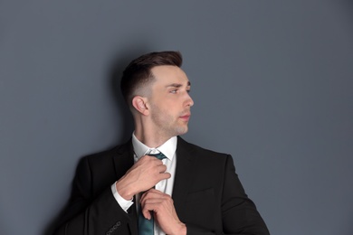 Portrait of young man with beautiful hair on grey background