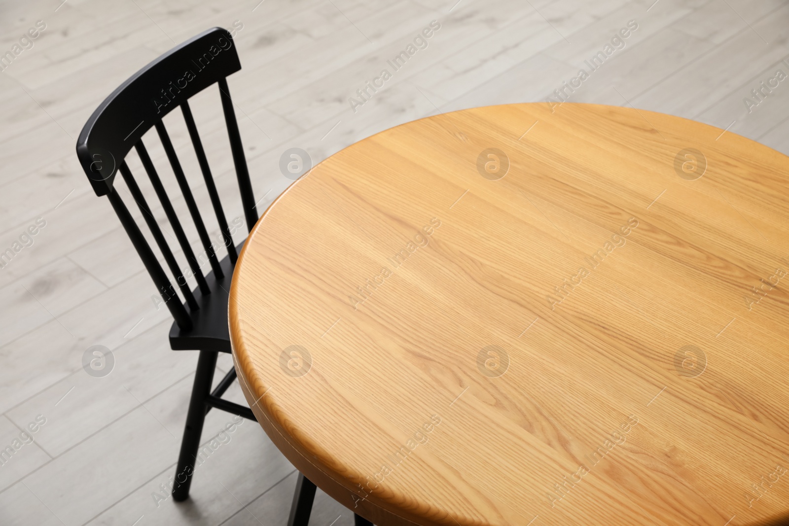 Photo of Stylish round table with black chair on floor