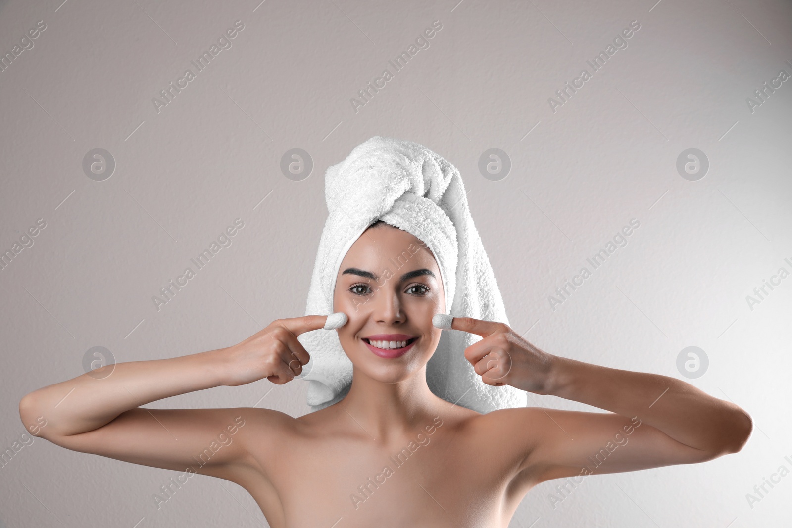 Photo of Woman using silkworm cocoons in skin care routine on light grey background