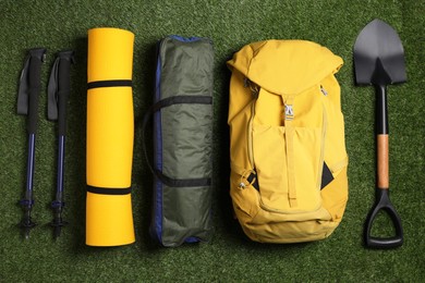 Photo of Set of traveler's equipment on green grass, flat lay