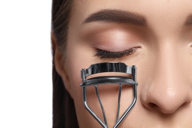 Woman using eyelash curler on white background, closeup