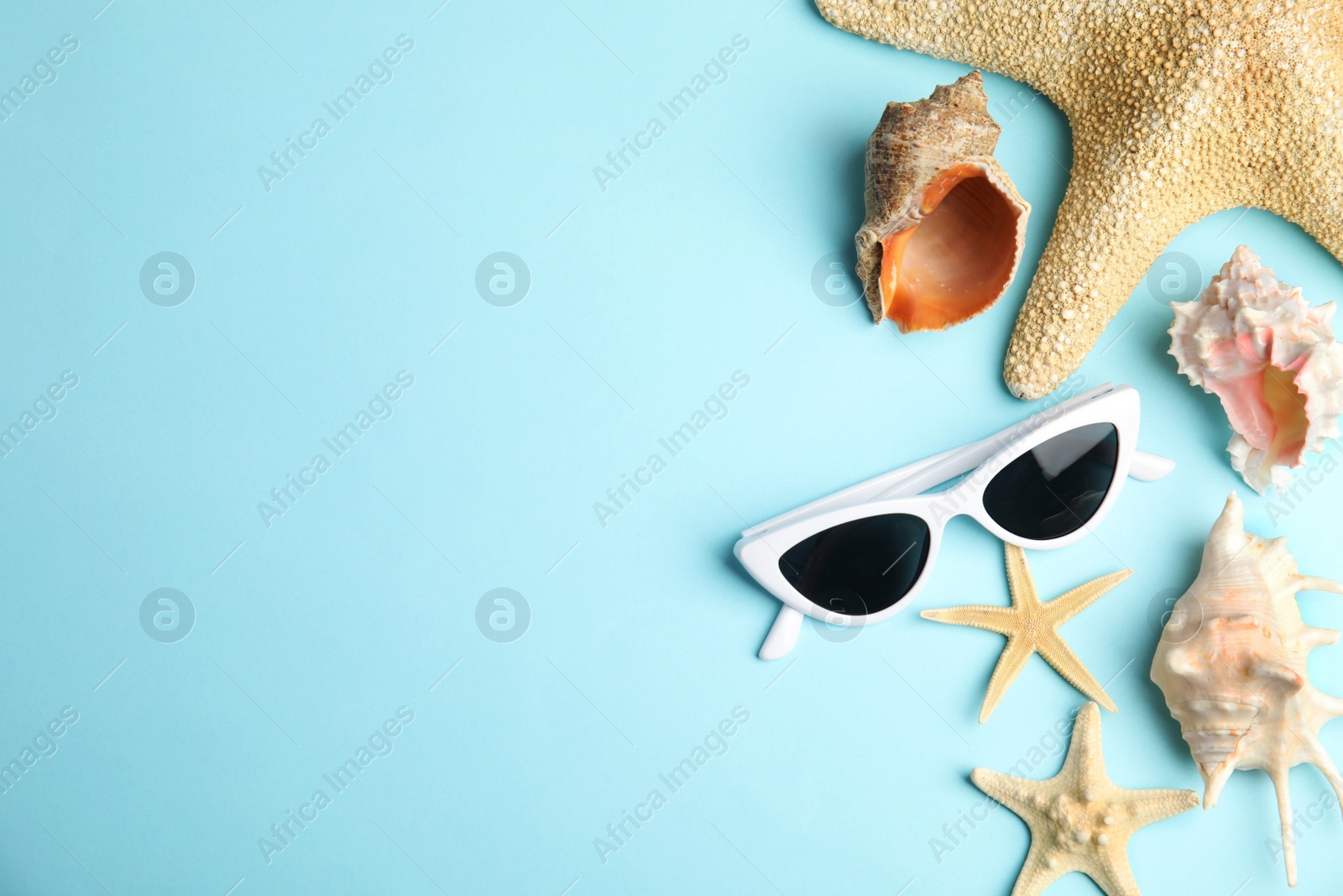 Photo of Flat lay composition with beach objects on blue background. Space for text