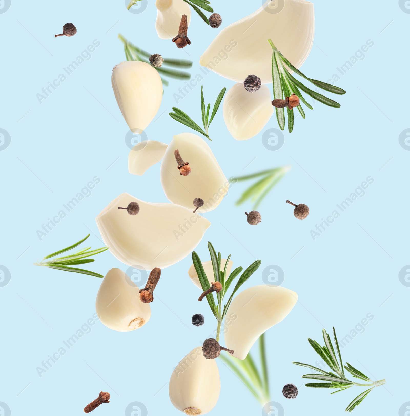 Image of Fresh peeled garlic, cloves, peppercorns and rosemary flying on light blue background