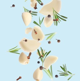 Image of Fresh peeled garlic, cloves, peppercorns and rosemary flying on light blue background