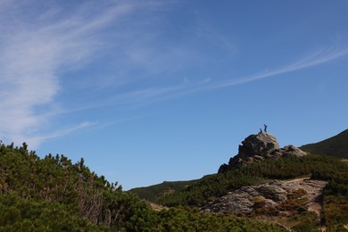 Tourists on cliff in mountains. Space for text