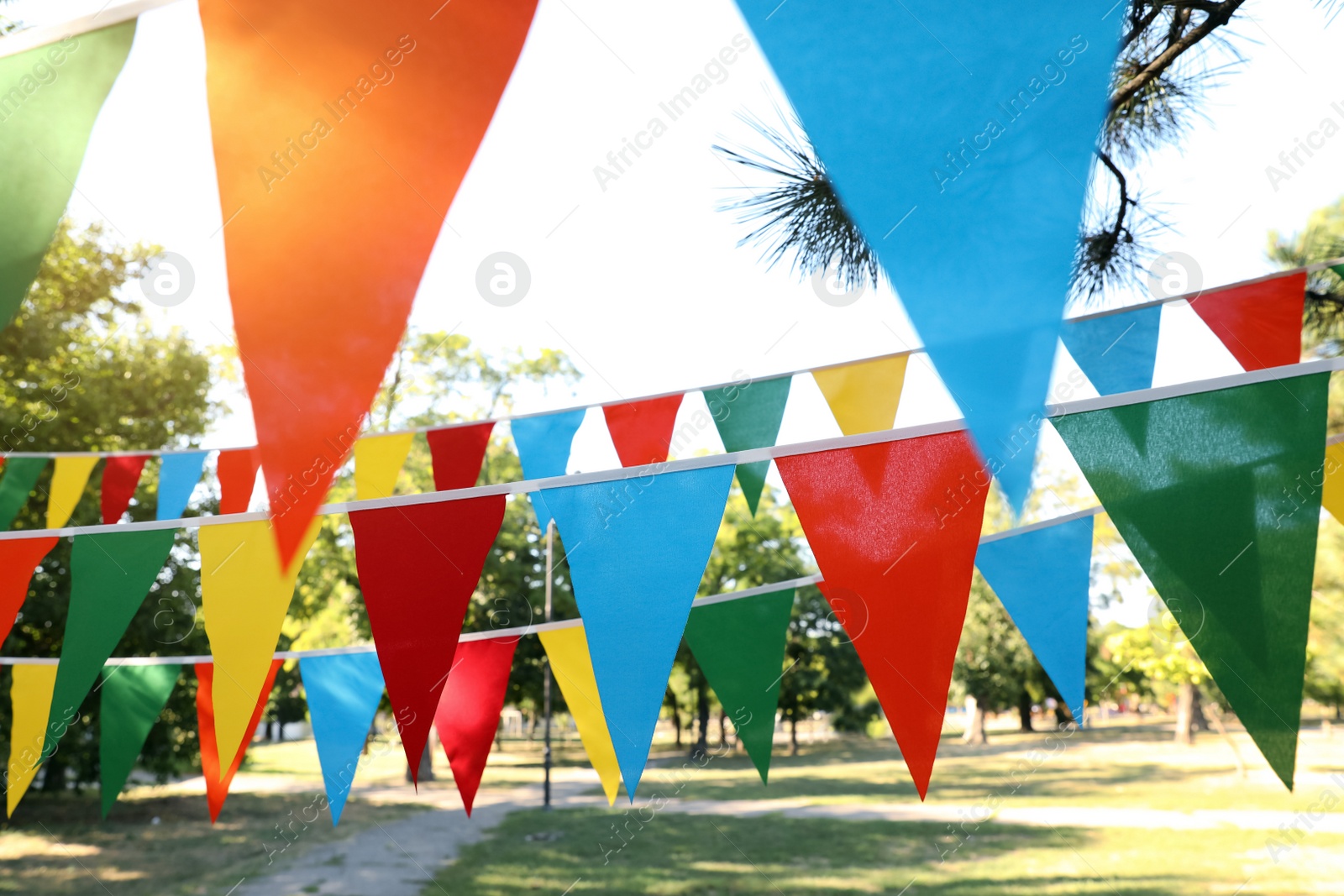 Photo of Colorful bunting flags in park. Party decor