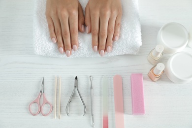 Photo of Woman waiting for manicure and tools at table, top view. Spa treatment
