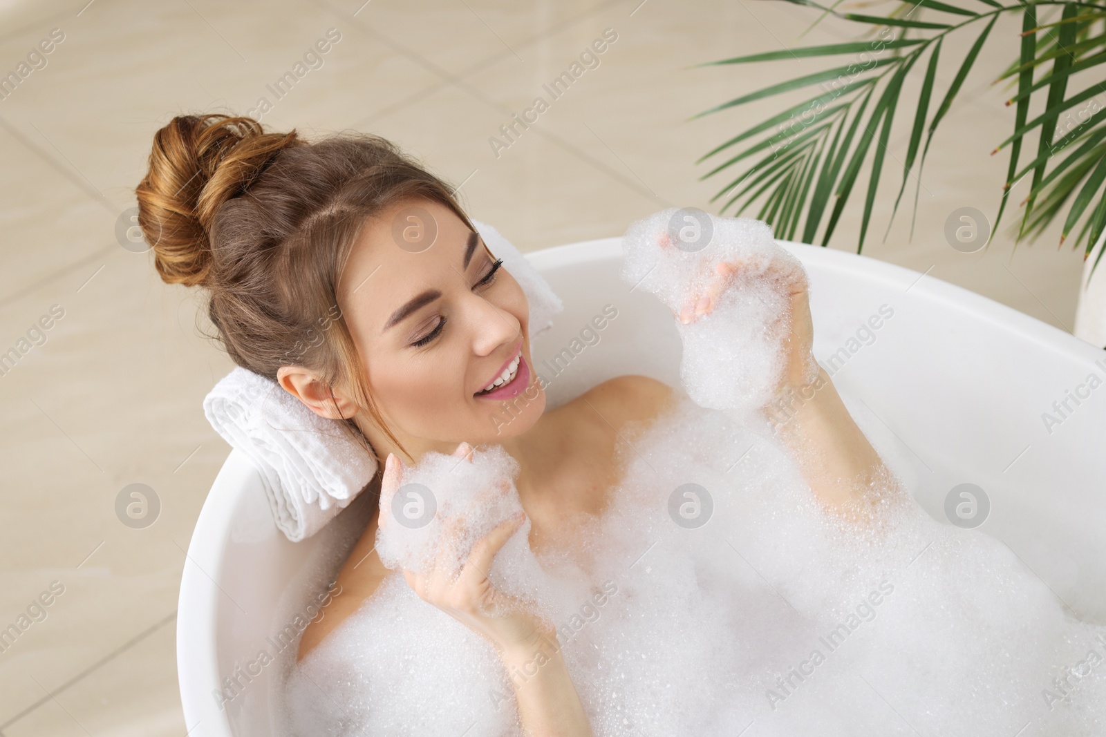 Photo of Beautiful woman enjoying bubble bath at home