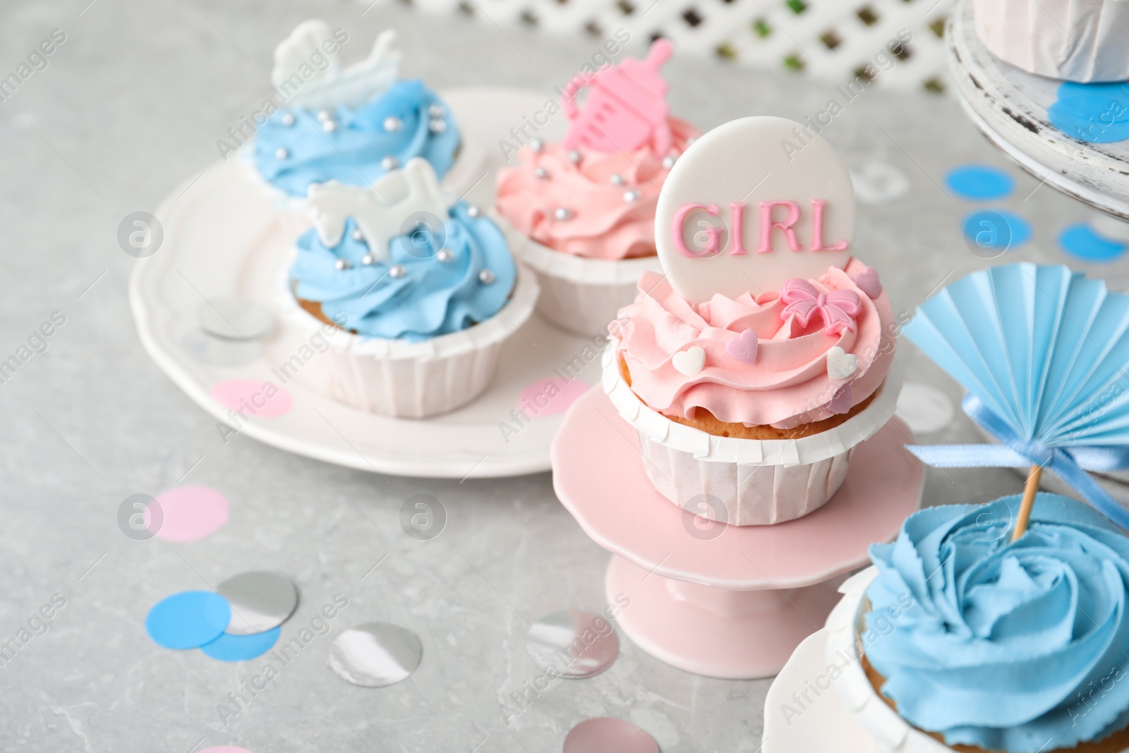 Photo of Delicious cupcakes with light blue and pink cream for baby shower on grey table