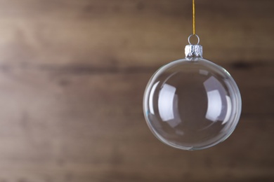 Photo of Transparent glass Christmas ball on blurred background. Space for text