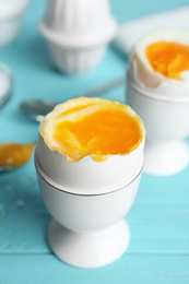 Photo of Soft boiled chicken egg served on light blue table