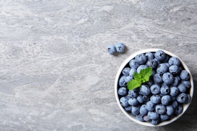 Photo of Crockery with fresh blueberries and space for text on table, top view