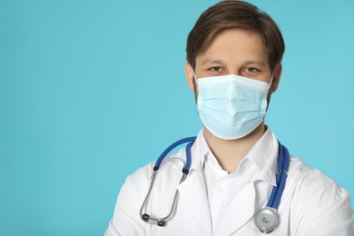 Photo of Doctor or medical assistant (male nurse) with protective mask and stethoscope on turquoise background