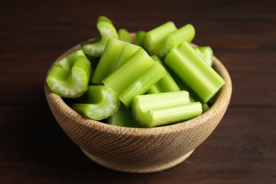 Photo of Cut celery in bowl on wooden table