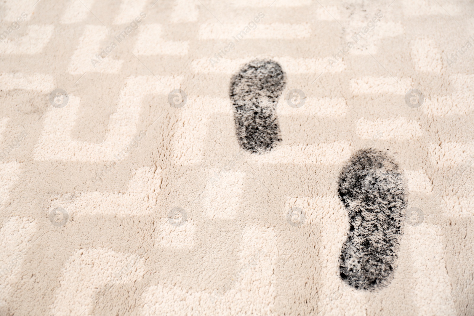 Photo of Trail of muddy footprints on beige carpet