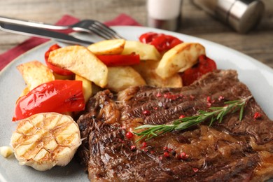 Photo of Delicious grilled beef steak and vegetables on plate, closeup