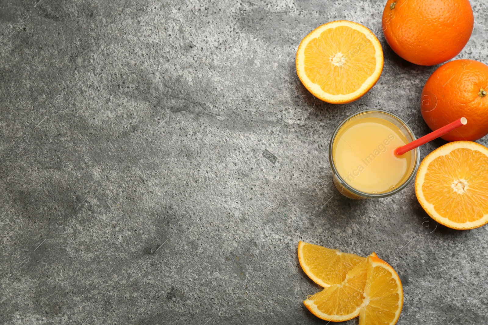 Photo of Delicious orange juice and fresh fruits on grey table, flat lay. Space for text