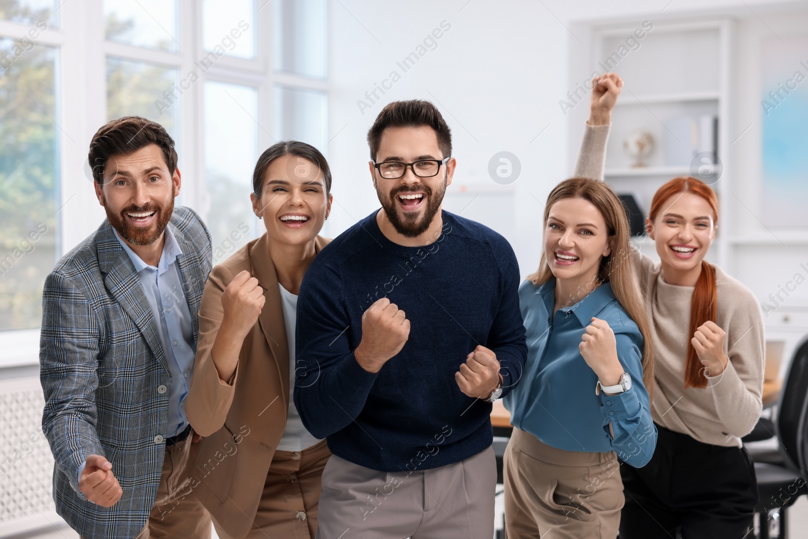 Photo of Team of employees celebrating success in office