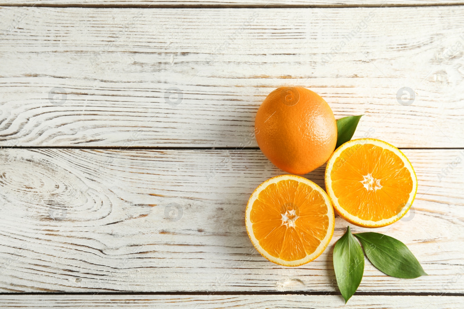 Photo of Flat lay composition with fresh oranges on wooden table. Space for text