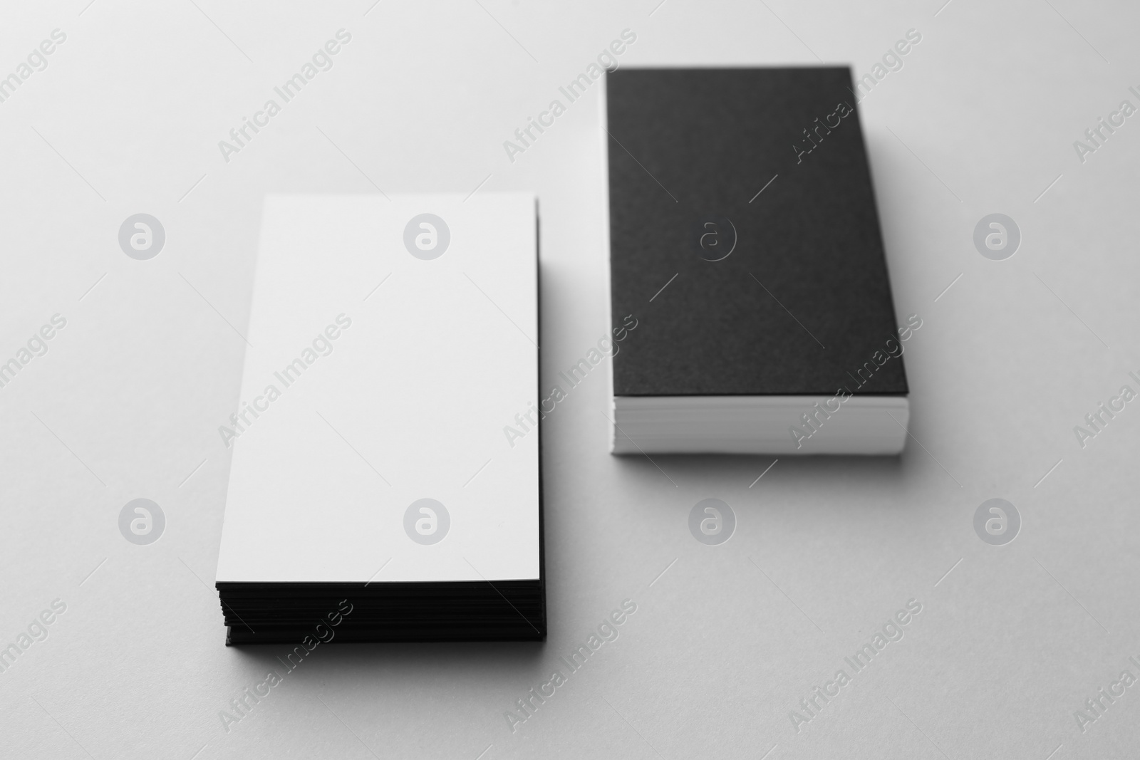 Photo of Blank black and white business cards on light background. Mockup for design