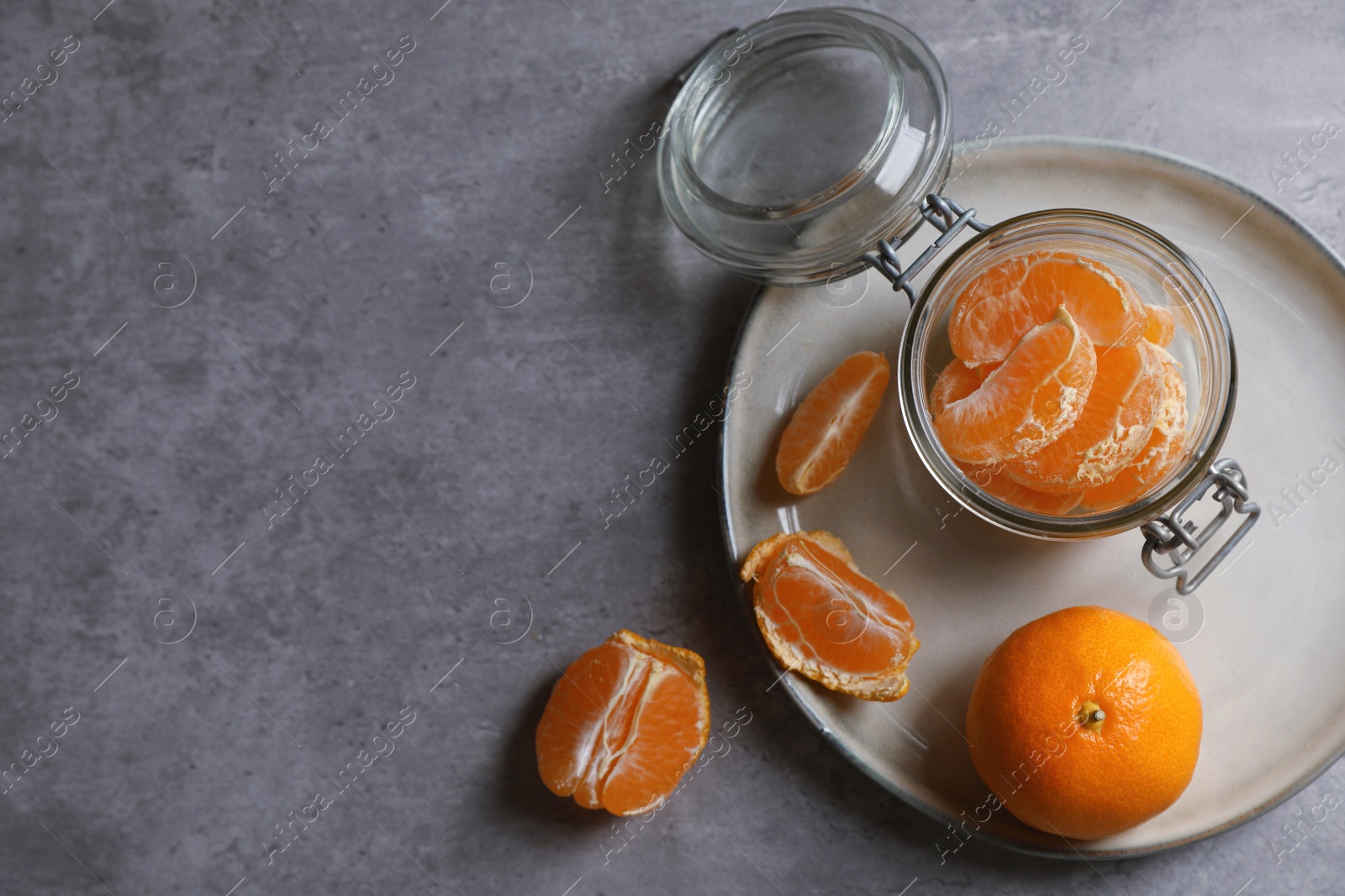 Photo of Fresh ripe tangerines on grey table, flat lay. Space for text