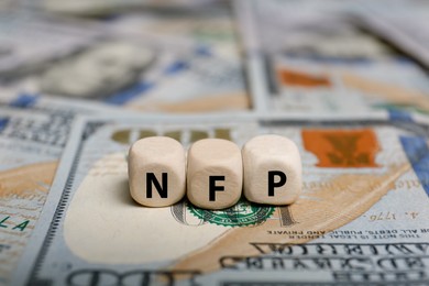 Photo of Cubes with abbreviation NFP on dollar bills