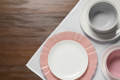 Beautiful ceramic dishware on wooden table, top view. Space for text