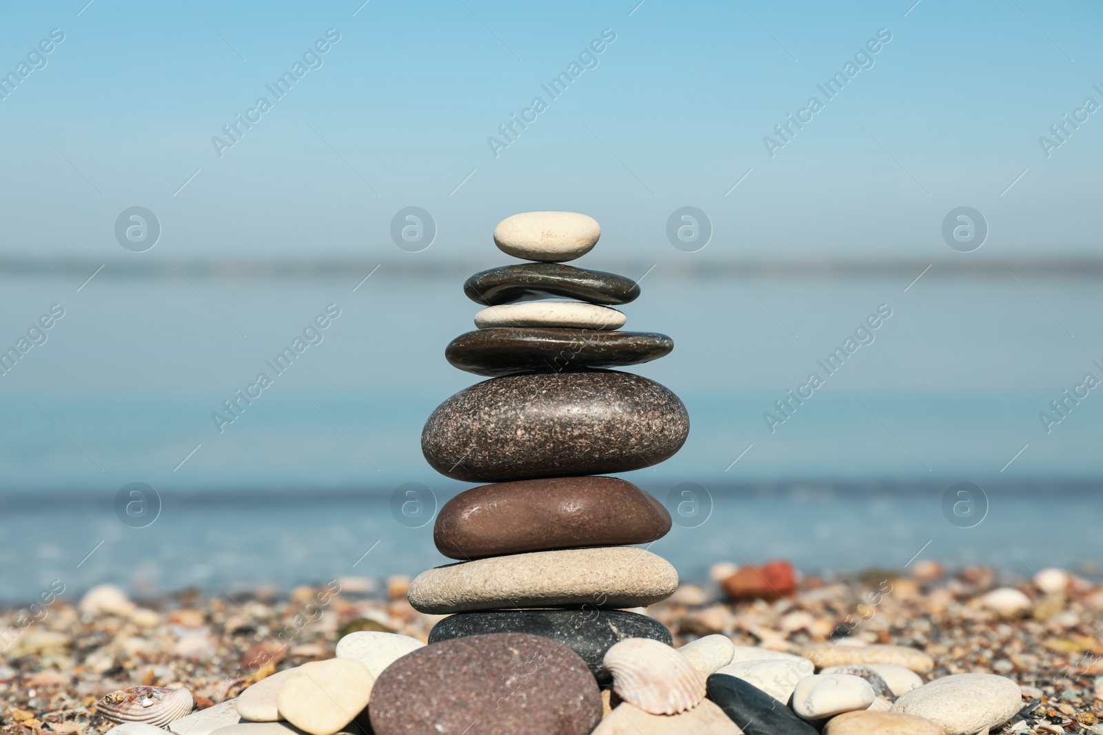 Photo of Stack of stones on beach, closeup. Harmony and balance concept