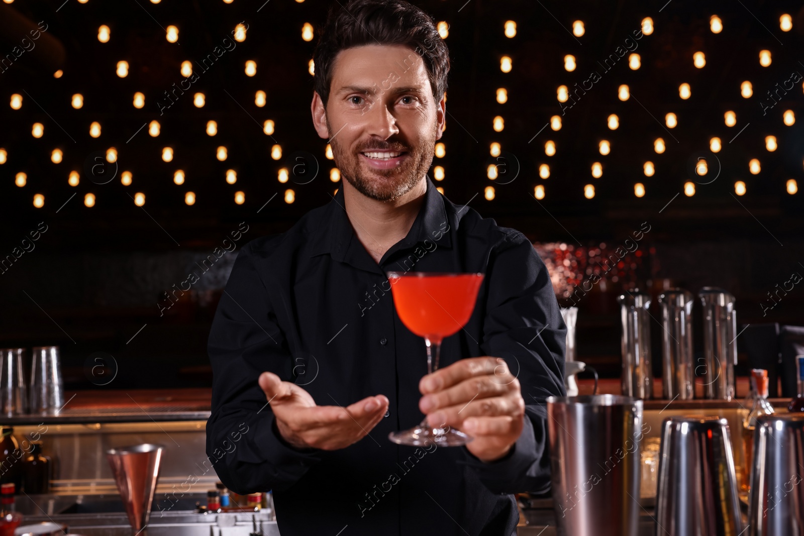 Photo of Bartender with fresh alcoholic cocktail in bar