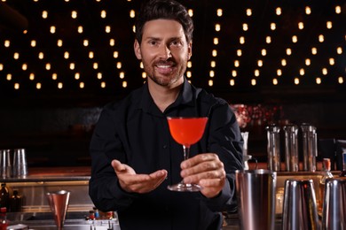 Photo of Bartender with fresh alcoholic cocktail in bar