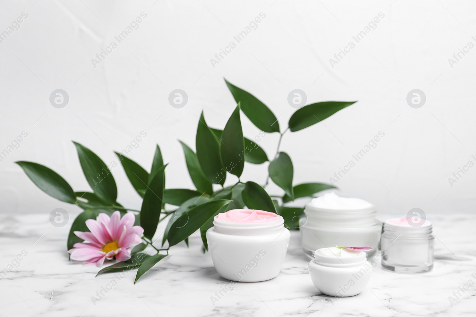 Photo of Composition with body cream in jars on light background